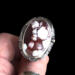front view on thumb, large oval wild horse magnesite gemstone silver statement ring, bezel set with stamped cutout wire accent
